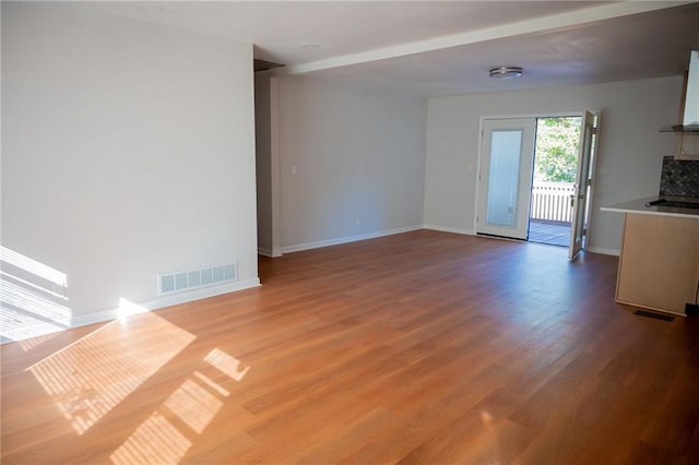 unfurnished living room featuring wood-type flooring and french doors