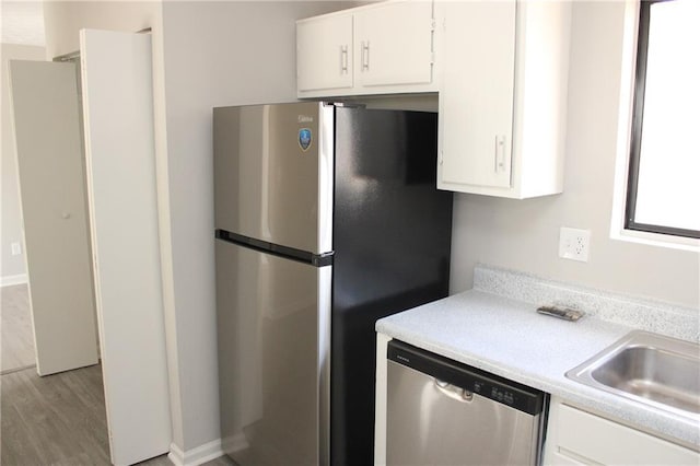 kitchen with white cabinetry, sink, light wood-type flooring, and appliances with stainless steel finishes