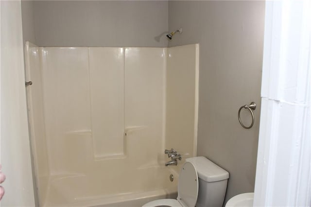 bathroom featuring shower / washtub combination and toilet