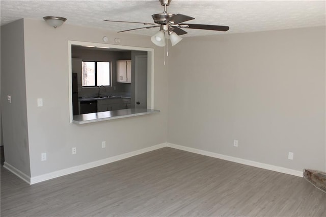 spare room with hardwood / wood-style floors, sink, a textured ceiling, and ceiling fan