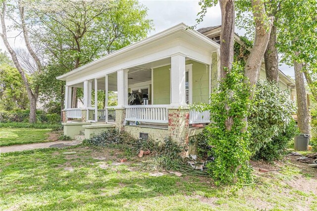view of front of house with a front yard, a porch, and crawl space