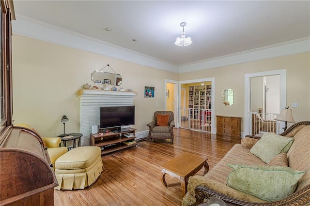living room featuring crown molding, wood finished floors, and a fireplace