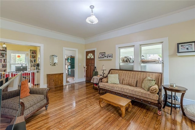 living room featuring crown molding, light wood finished floors, and baseboards
