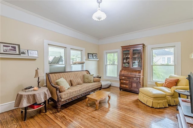 living area with light wood finished floors, baseboards, and crown molding