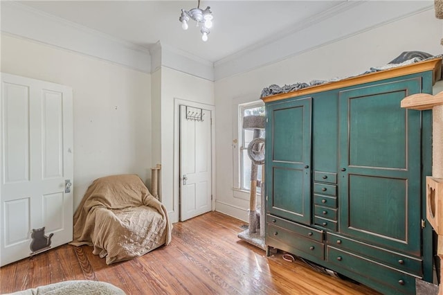 sitting room featuring crown molding, baseboards, and wood finished floors