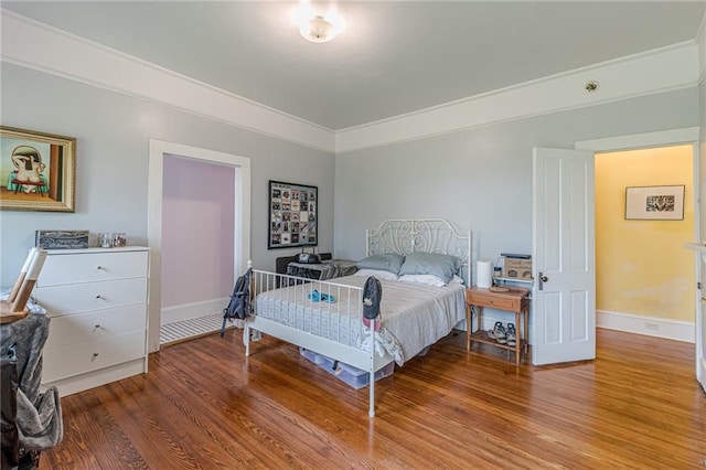 bedroom with wood finished floors and baseboards