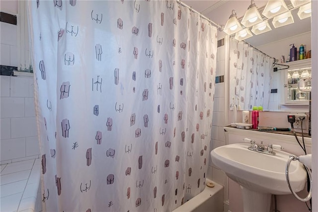 bathroom featuring a sink, tile patterned floors, and shower / bath combo with shower curtain