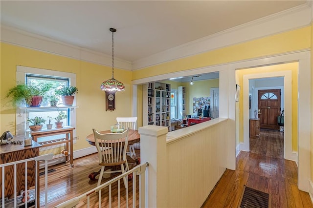 dining area featuring baseboards, hardwood / wood-style floors, and ornamental molding