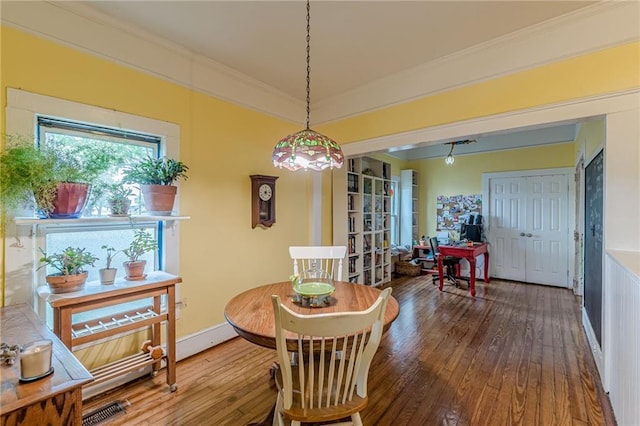dining area with wood-type flooring, visible vents, and crown molding