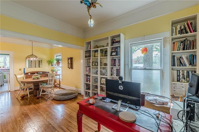interior space with hardwood / wood-style floors, built in features, baseboards, and ornamental molding