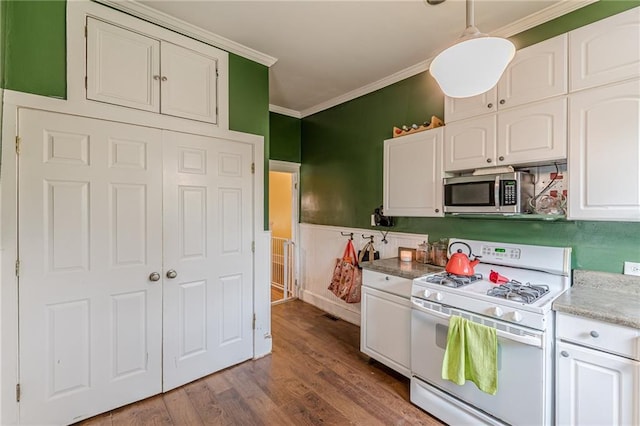 kitchen with stainless steel microwave, white range with gas cooktop, white cabinetry, crown molding, and wood finished floors