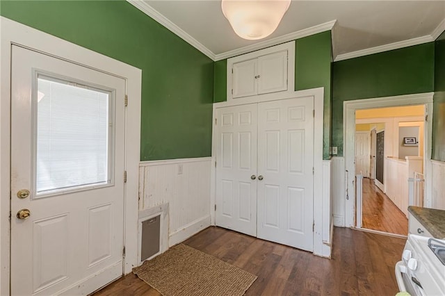 interior space featuring crown molding, dark wood-style floors, and a wainscoted wall