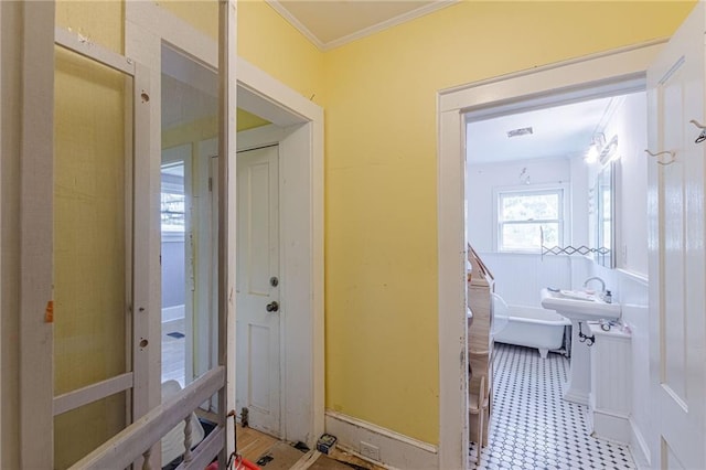 hall with crown molding and a sink