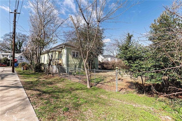view of property exterior with fence and a lawn