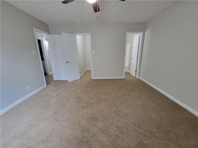 unfurnished bedroom featuring ceiling fan, light carpet, a textured ceiling, and ensuite bath