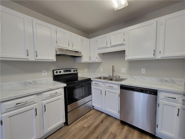 kitchen with stainless steel appliances, sink, light hardwood / wood-style flooring, and white cabinets