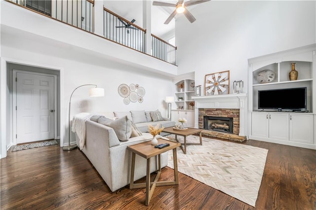 200 Glen Wood Pl, Canton, GA 30114 - living area with a high ceiling, a ceiling fan, built in features, a fireplace, and dark wood-type flooring