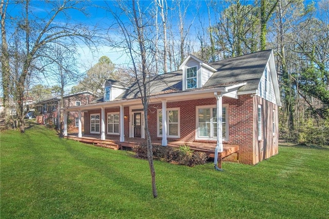 new england style home with a front yard and covered porch