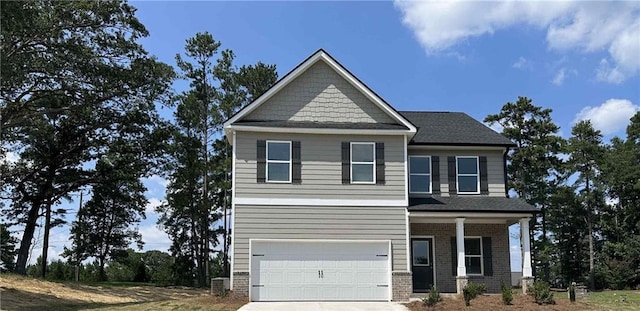 craftsman inspired home featuring a garage, concrete driveway, brick siding, and a porch