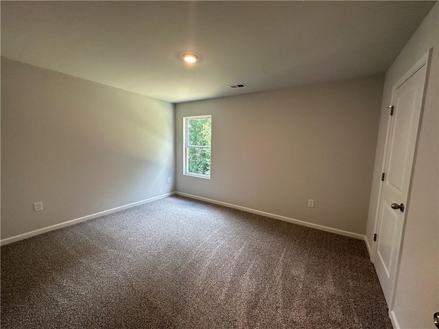 carpeted spare room featuring baseboards