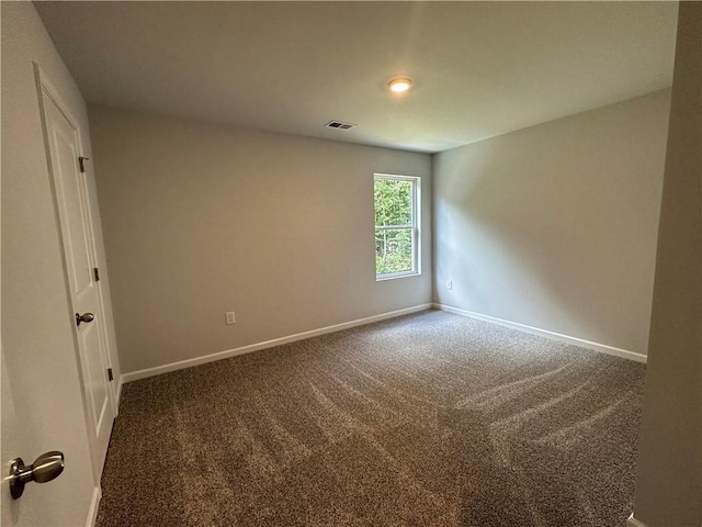 carpeted empty room featuring baseboards