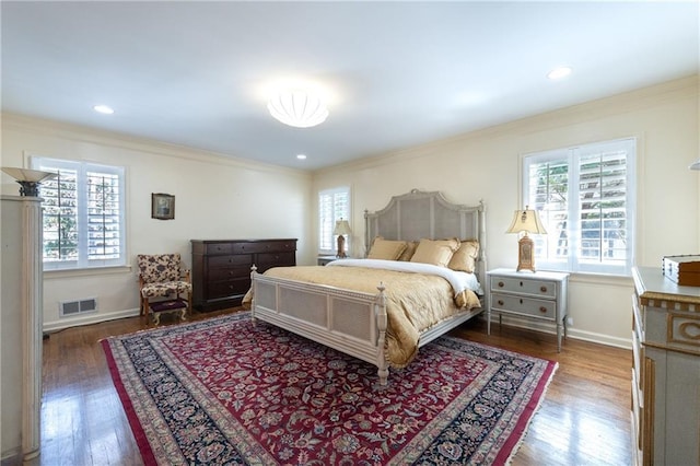 bedroom featuring wood finished floors, visible vents, multiple windows, and ornamental molding