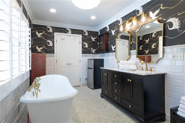 bathroom with ornamental molding, a sink, wainscoting, wallpapered walls, and a freestanding bath