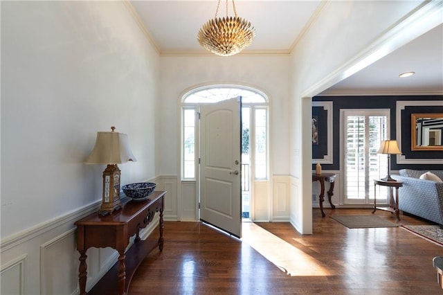 foyer with wainscoting, crown molding, and wood finished floors