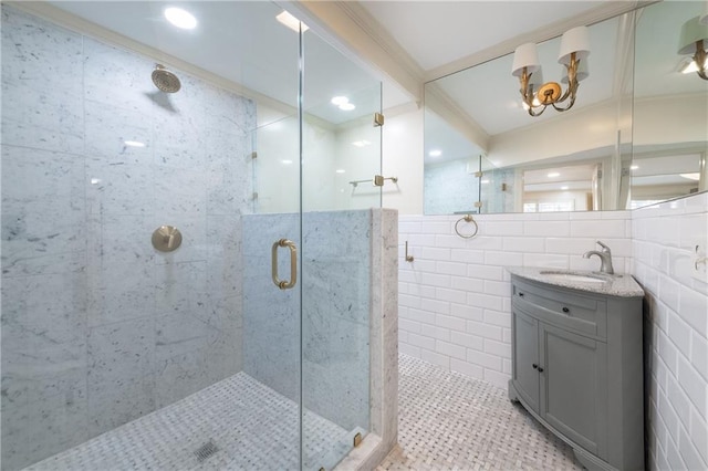 full bathroom with vanity, tile walls, crown molding, and a shower stall