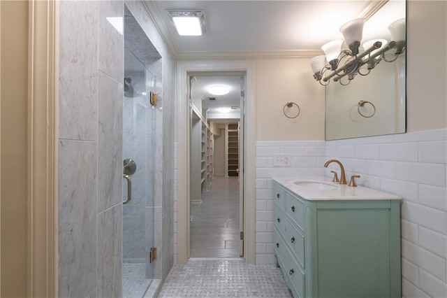 full bath with ornamental molding, tile walls, wainscoting, a shower stall, and vanity