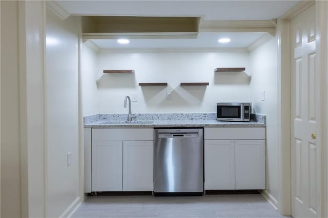 kitchen with open shelves, crown molding, light stone counters, appliances with stainless steel finishes, and a sink