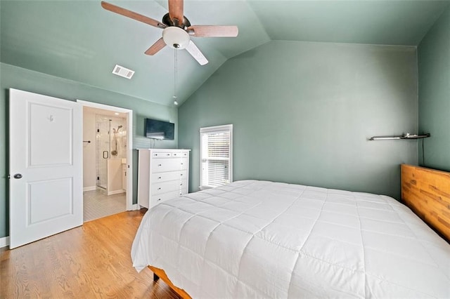 bedroom with hardwood / wood-style floors, vaulted ceiling, ceiling fan, and ensuite bathroom