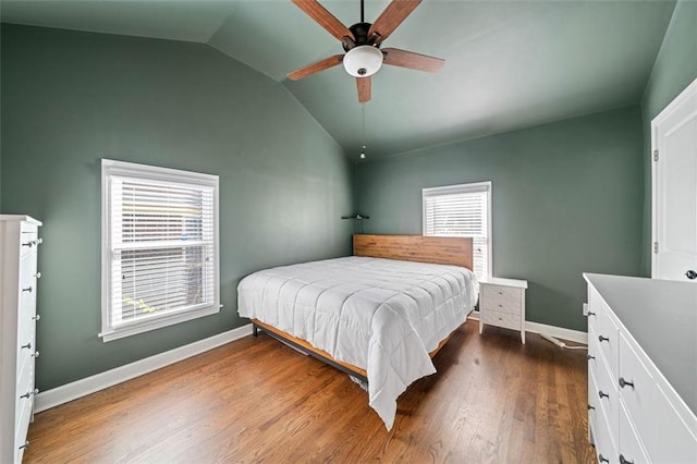 bedroom with ceiling fan, lofted ceiling, dark hardwood / wood-style floors, and multiple windows