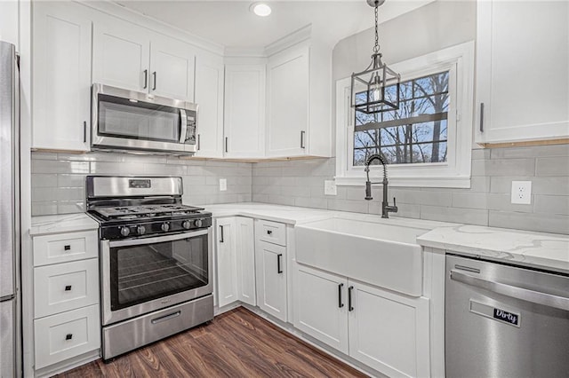 kitchen featuring dark wood-type flooring, a sink, light stone counters, white cabinetry, and stainless steel appliances