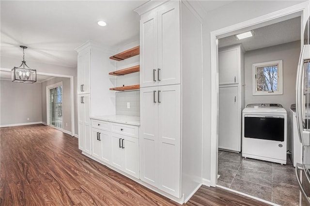 hallway featuring baseboards, recessed lighting, dark wood-style flooring, washer and dryer, and a chandelier