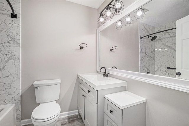 full bath with vanity, wood finished floors, baseboards, walk in shower, and toilet