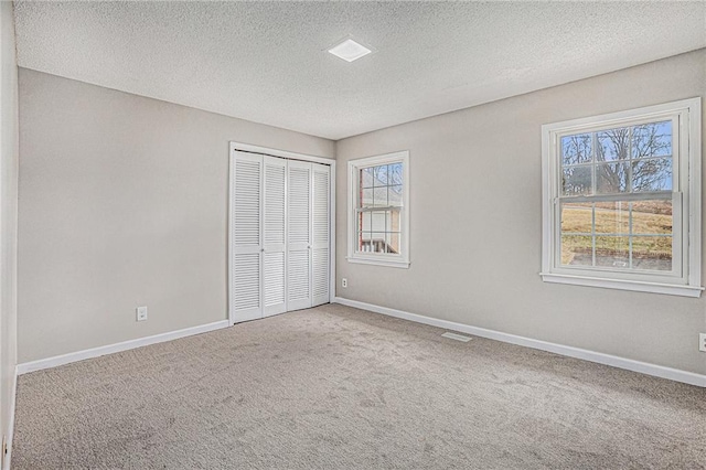 unfurnished bedroom with a closet, baseboards, and carpet flooring