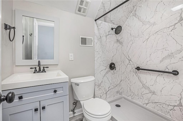 bathroom featuring a shower, visible vents, toilet, and vanity