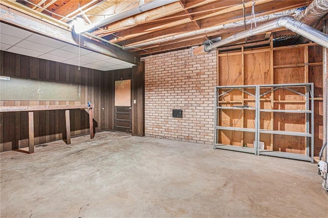 unfinished basement featuring wooden walls