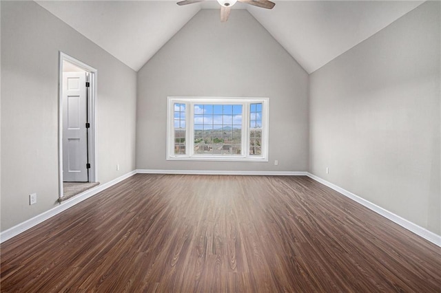 spare room featuring dark wood-type flooring, baseboards, lofted ceiling, and ceiling fan