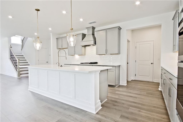 4212 Adler Cir, Buford, GA 30519 - kitchen featuring gray cabinets, custom range hood, decorative backsplash, and a sink