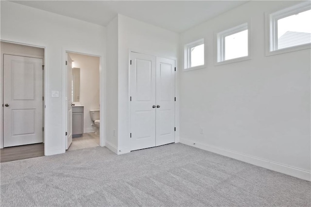 4212 Adler Cir, Buford, GA 30519 - unfurnished bedroom featuring baseboards, connected bathroom, a closet, and light carpet