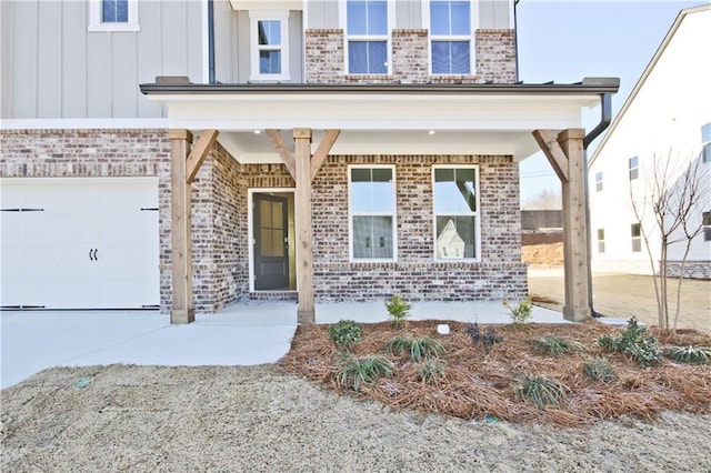 4212 Adler Cir, Buford, GA 30519 - doorway to property with driveway, brick siding, and board and batten siding