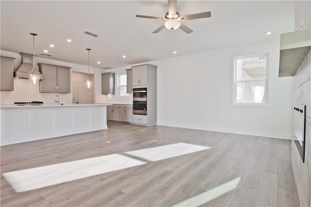 4212 Adler Cir, Buford, GA 30519 - kitchen with open floor plan, tasteful backsplash, premium range hood, gray cabinets, and visible vents