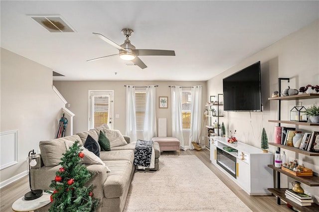 living room featuring ceiling fan and light hardwood / wood-style floors