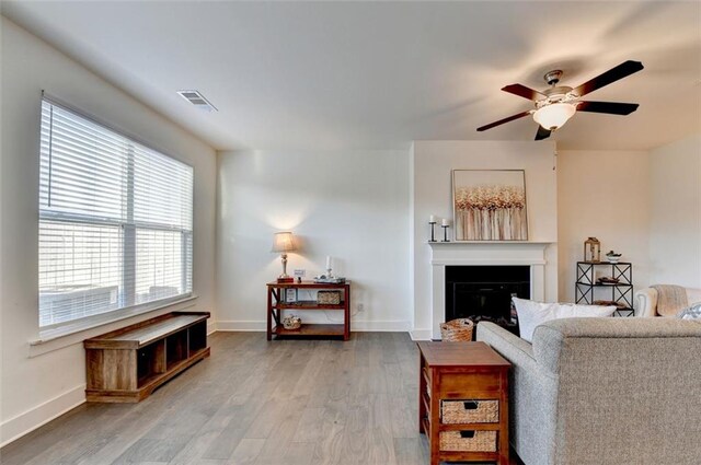 living room featuring wood-type flooring, a wealth of natural light, and ceiling fan