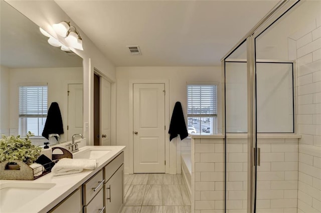 bathroom featuring vanity and shower with separate bathtub