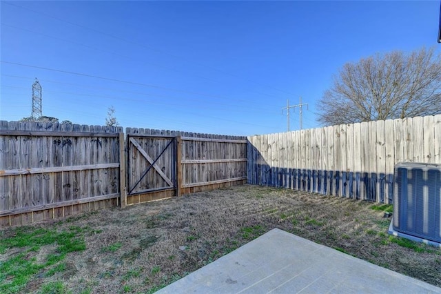 view of yard with central AC unit and a patio area