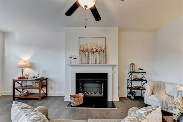 living room featuring ceiling fan and dark wood-type flooring