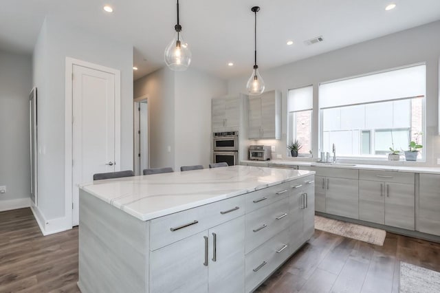 kitchen with visible vents, pendant lighting, dark wood finished floors, and a center island